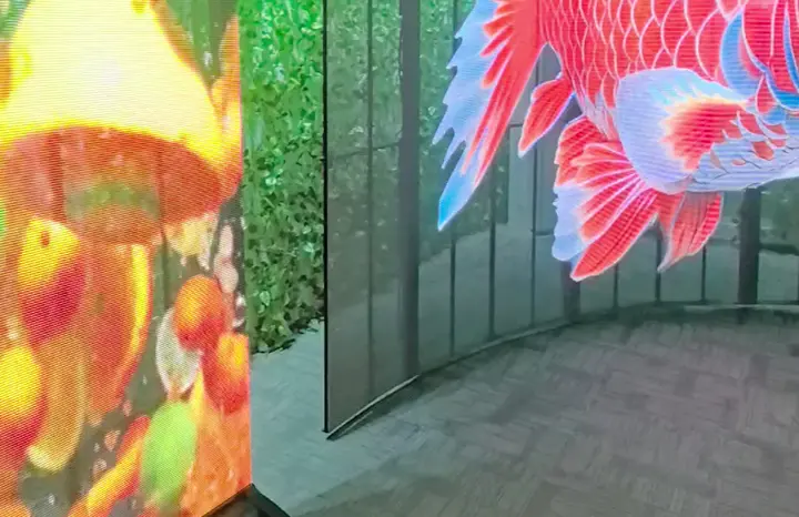 Böjd transparent LED-panel i ett showroom, med väggen bakom synlig genom bilden, och en fristående transparent skärm bredvid